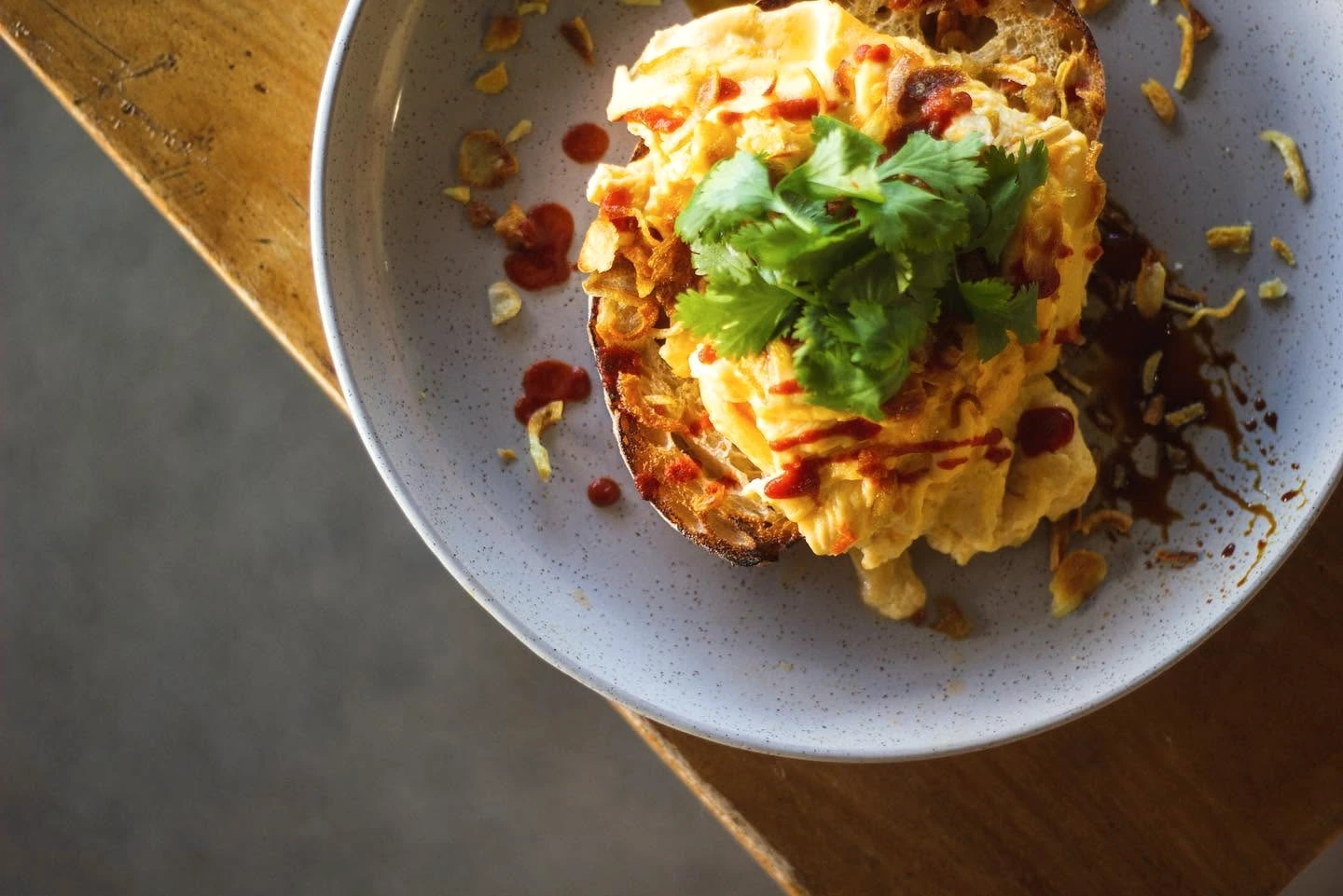 A freshly prepared breakfast dish on the sunny wooden table at Lotus Cafe